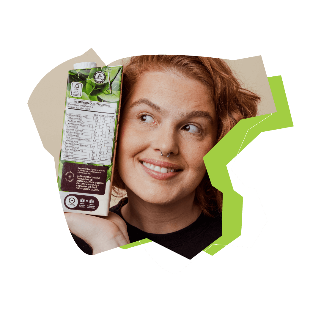 Mulher ruiva sorrindo e segurando uma caixa de suco com o selo eureciclo de compensação de 100%.